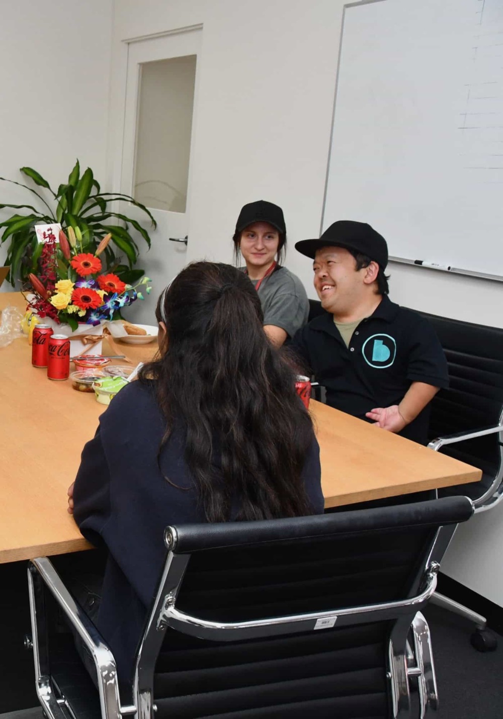 Sammy laughing with participants around a table at a group activity day
