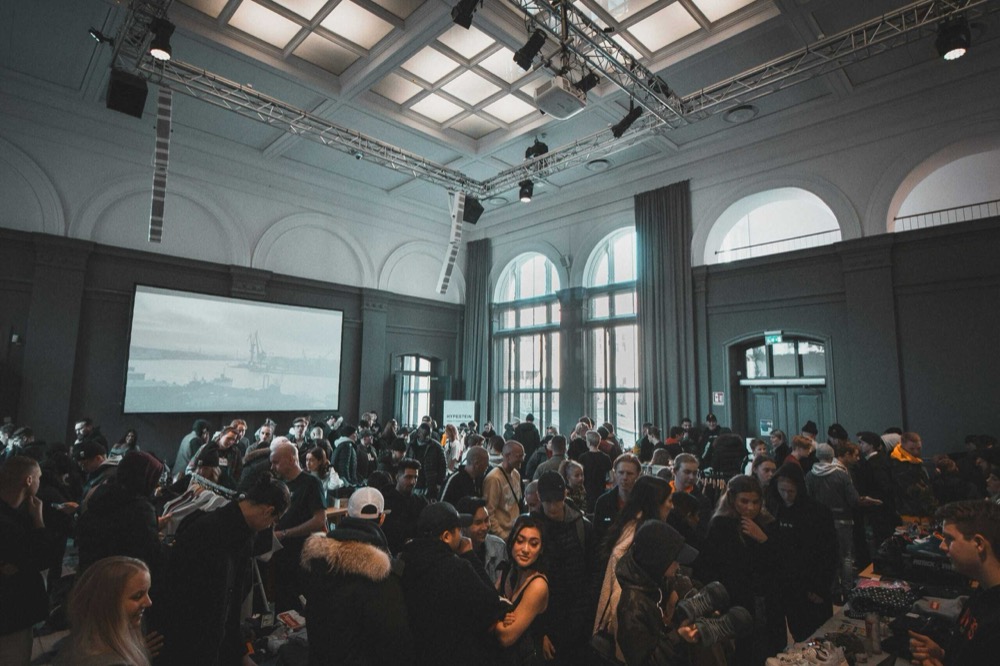 A packed crowd at a corporate event in a grand rigged hall