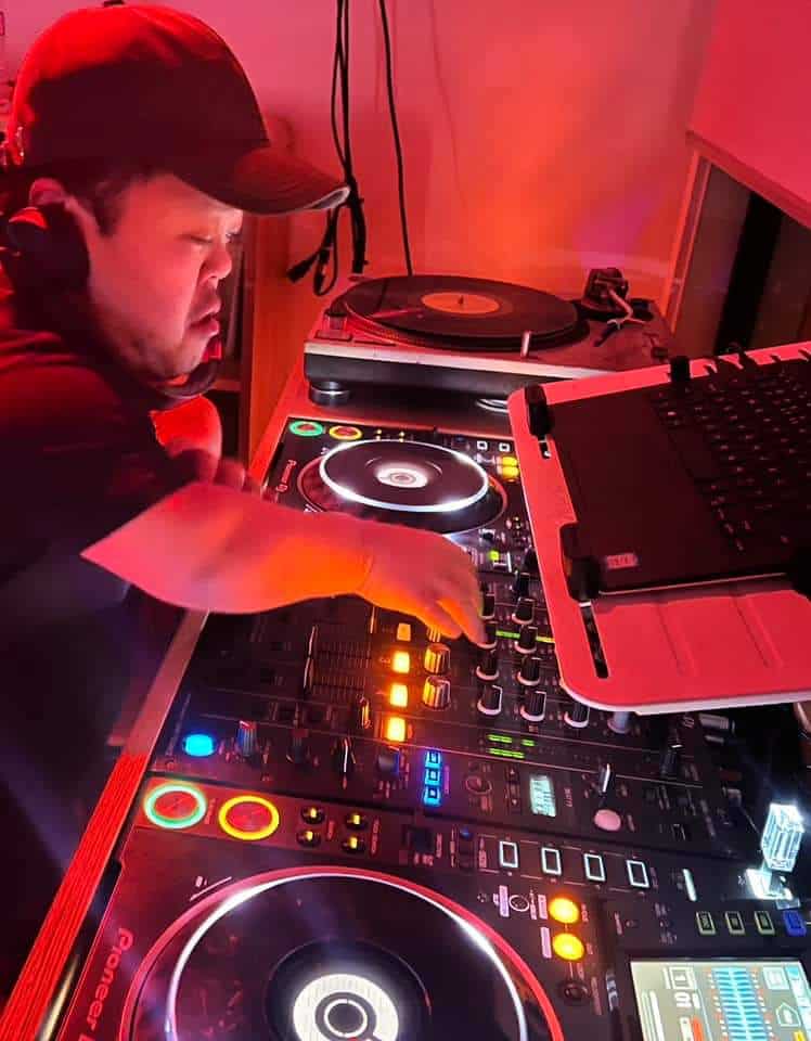 Sammy mixing on Pioneer CDJ decks under red stage lighting